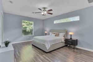 a bedroom with a bed and a ceiling fan