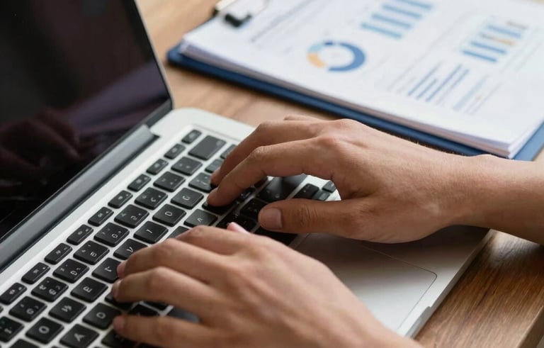 Close-up of hands typing on a modern laptop in a professional Brazilian workspace. Next to the laptop, a neatly prepared document with navy blue accents and professional charts. Shallow depth of field, focused on efficiency and detail.