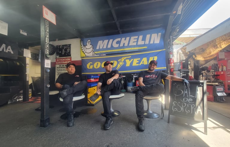Fast Tire Shop mechanics team taking a break at the East Los Angeles workshop under a Michelin and G