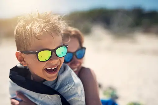 two boys wearing sunglasses and sunglasses on a beach