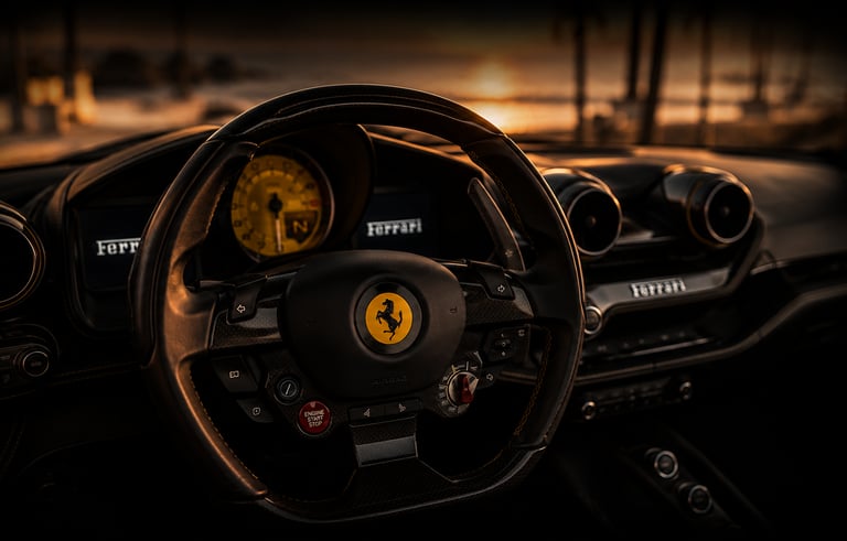 Luxury Ferrari car interior featuring a carbon fiber steering wheel at sunset.
