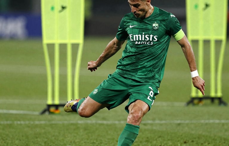 Dynamic action shot of a professional soccer player executing a powerful strike on a lush grass pitch. High-contrast lighting highlights Performance Green and Energetic Lime training markers in the background. Global / Spanish-speaking environment.