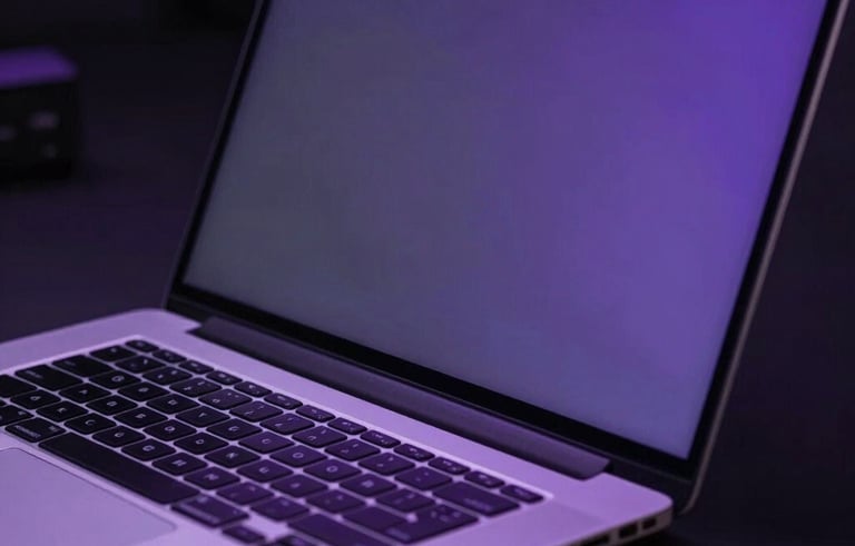 Close-up photography of a high-performance laptop screen in a dark modern environment. Soft purple glow reflects on sleek metal in a professional setting.