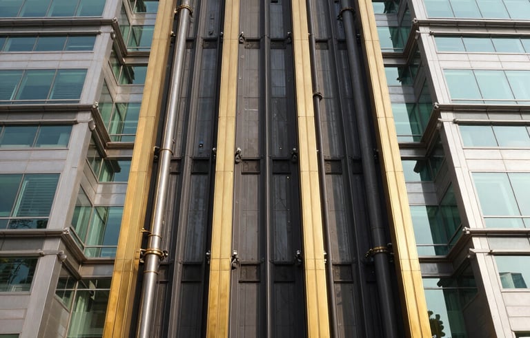A wide architectural shot of a grand South Asian government headquarters featuring high-tech glass-walled elevators. The composition is symmetrical and powerful, showcasing industrial sophistication. Sunlight glints off gold-colored steel frames and polished black surfaces.