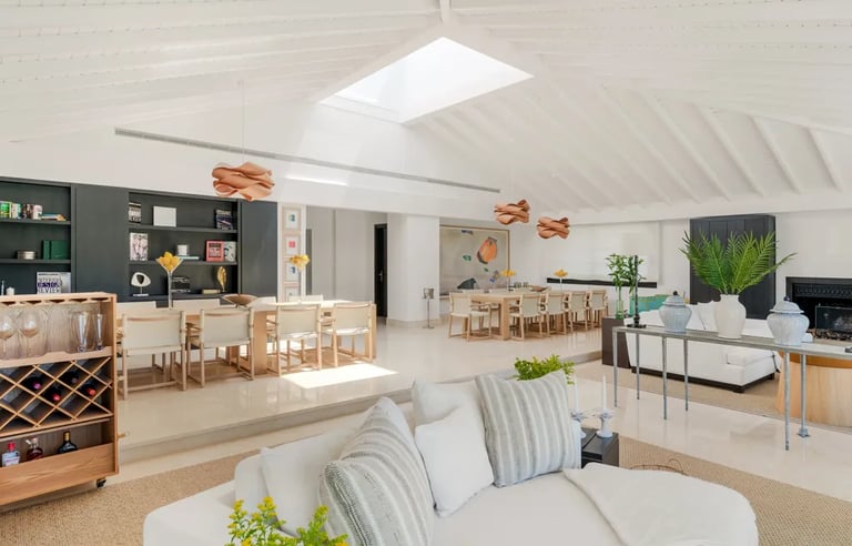 Spacious open-plan dining and lounge area with skylight at Villa El Olivo, Marbella