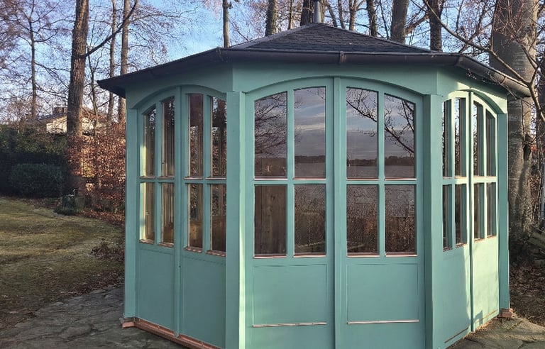 Maßgefertigter Holz-Pavillon in Türkis mit großen Sprossenfenstern und Kupferdach direkt am Seeufer am Ammersee.