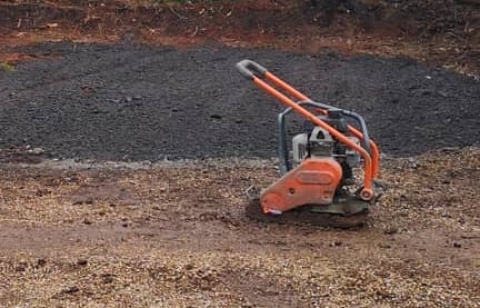 Petrol wacker plate compacting sub-base on construction site in the West Midlands