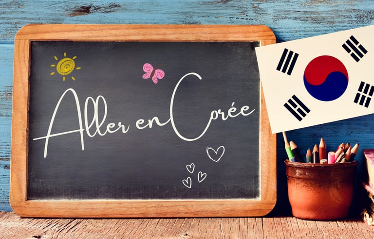 Tableau noir posé sur une table en bois avec l’inscription manuscrite  Aller en Corée
