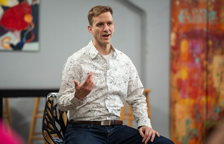 Remy sits gesturing during a small group talk