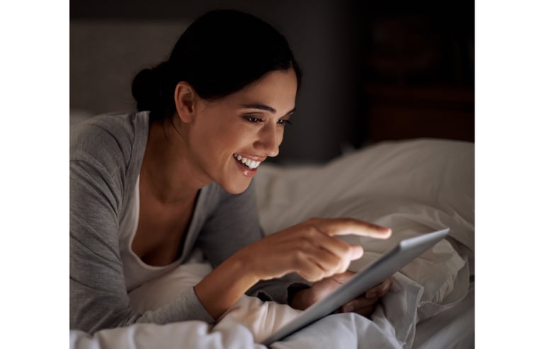 a woman is smiling and holding a tablet computer