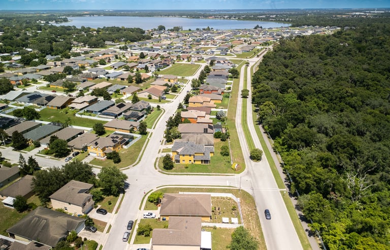 a city street with houses and trees in the background