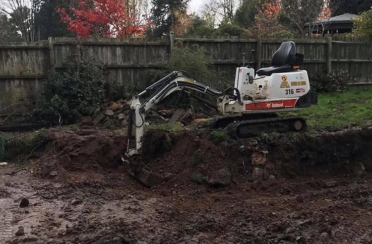 Mini digger excavating trench in Selly Oak garden