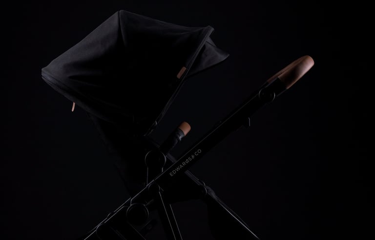 Product campaign photography - a black baby stroller with removable seat and brown leather handles