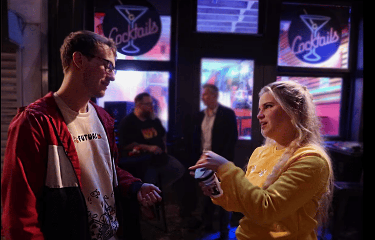 a man and woman standing in front of a bar