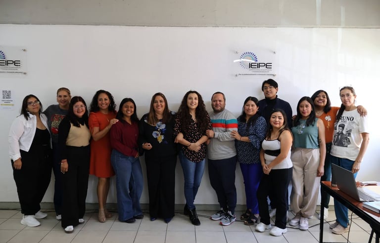 A group of diverse IEIPE education professionals smiling together in an office setting.