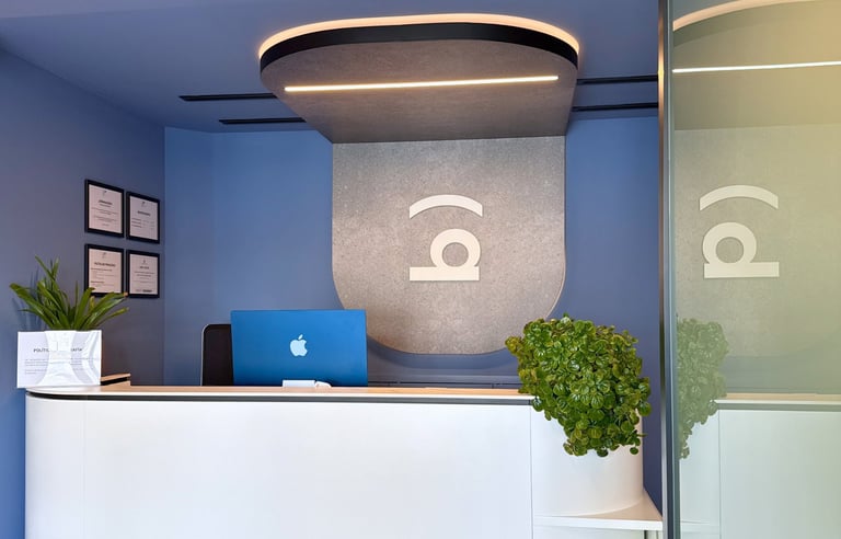 Recepción de la Clínica Bocarriba en Costa del Silencio, con un mostrador blanco y paredes azules