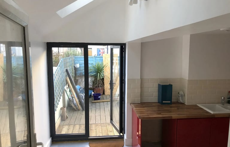 Modern rear house extension with bifold doors opening to garden in Brighton by T.L.E Constructing.