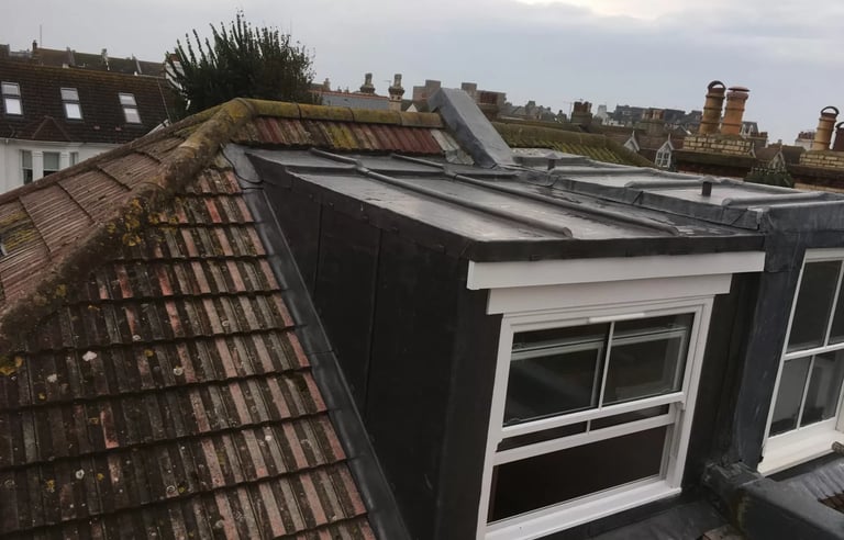 Loft conversion with dormer window added to roof of Brighton home.
