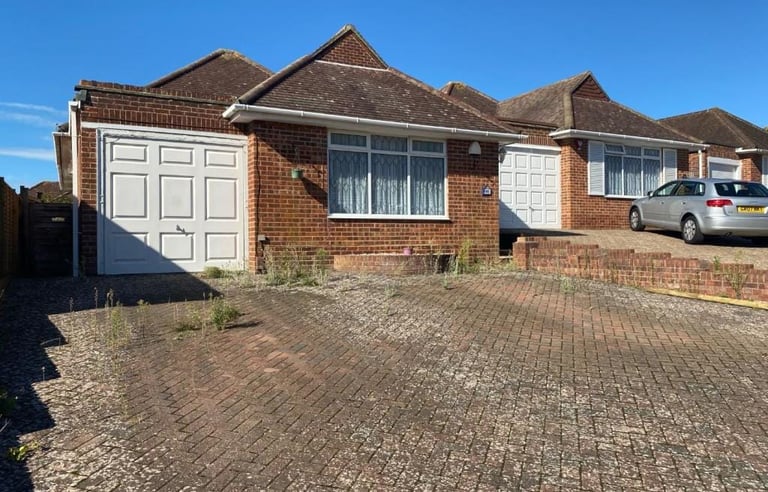 Brick bungalow with attached garage before extension or conversion renovation.