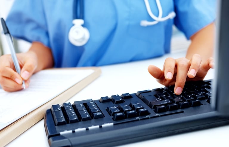 Nurse typing documentation on the keyboard..