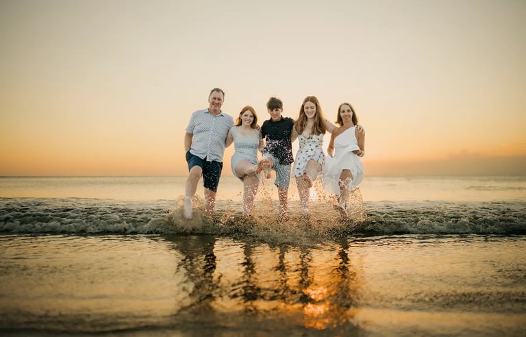 Family playing together in the shallow sea during a sunset family photography session at Jimbaran Beach Bali
