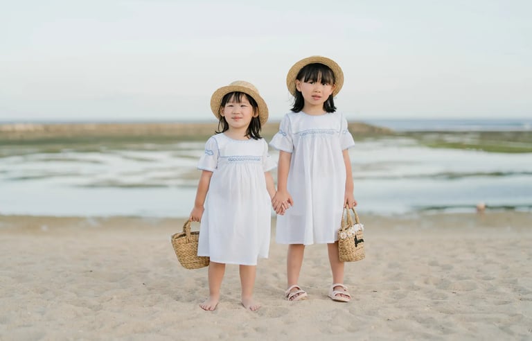 Two sisters standing together on the beach at The Apurva Kempinski Bali.