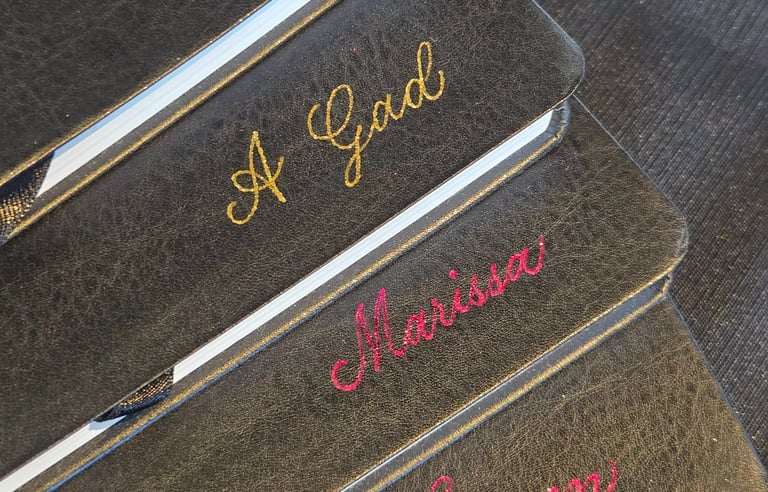 Hot foiling on leather notebooks for a conference done by Handwritten by Belle.