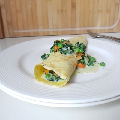 rolled German pancake on white plate with green veggies - copyright Tanja Dietzig