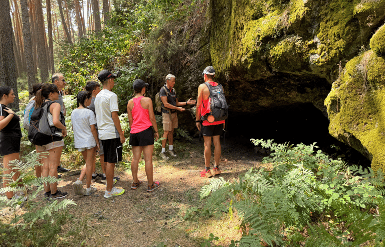 grupo de alumnos escuchando la explicacion del instructor sobre el refugio natural de una cuevando 
