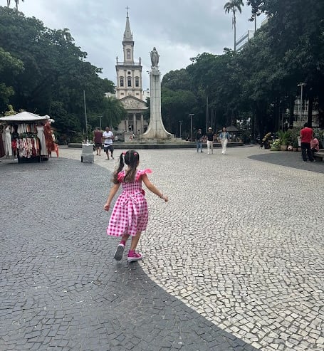 Pequena Victoria correndo pelo Largo do Machado.