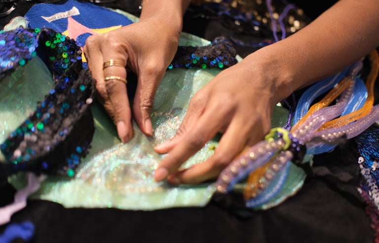 Two hands pinch beads and pearls on a textile work playing sounds and vibes of underwater recordings