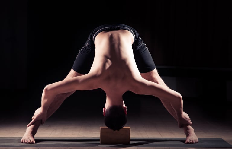 Hombre haciendo Hatha Yoga postura Prasarita Padottanasana