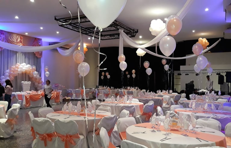 a room with many tables and chairs and balloons