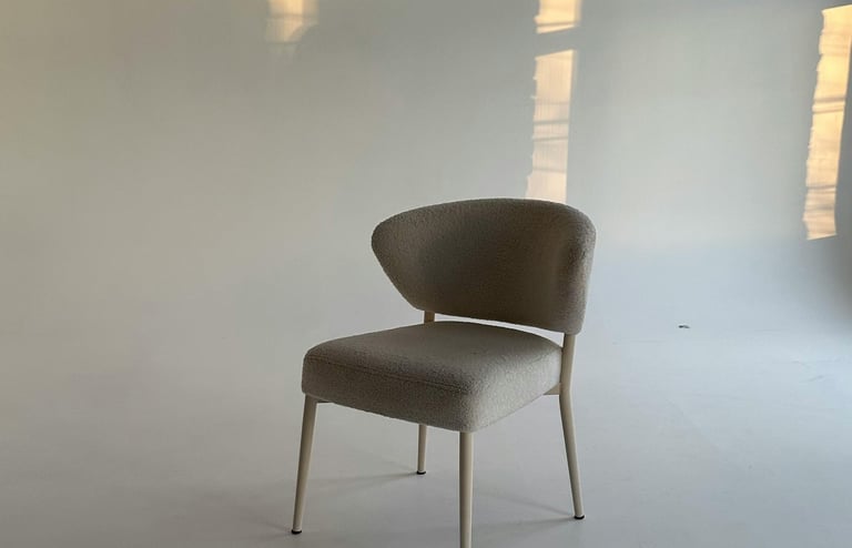 Een eenzame stoel op een glimmend witte vloer die lijkt te reflecteren als ijs. Symboliseert stilte.