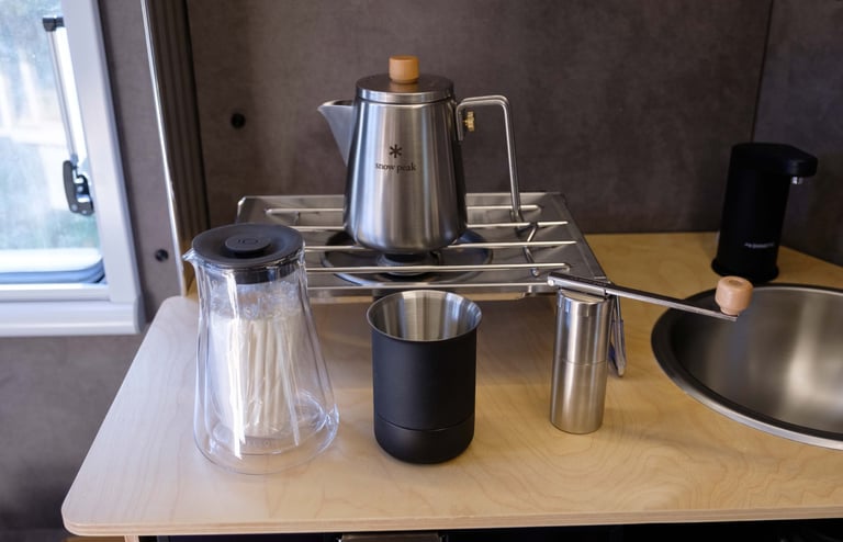 Snow Peak flat burner, kettle, and burr hand grinder, along with a Fellow Stag pour over kit.