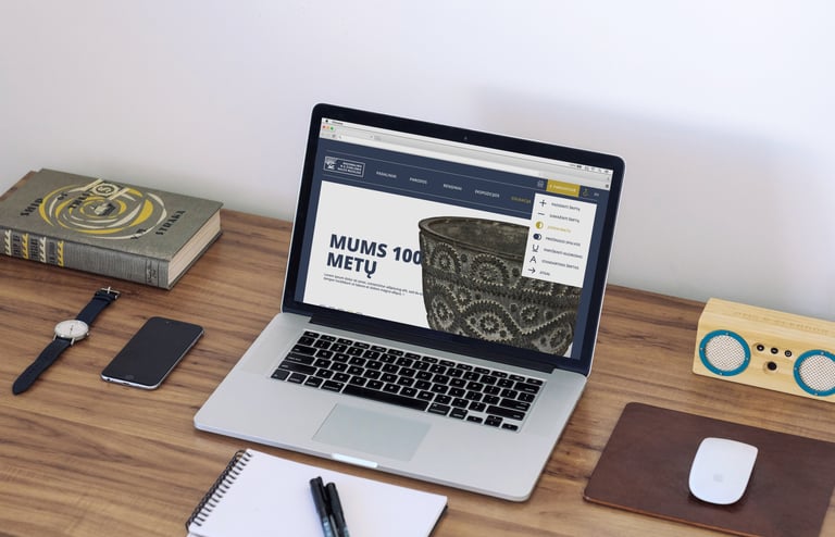 A laptop with the front page of the museum's website is open. 