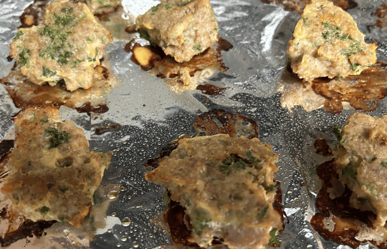 Turkey meatballs on pan covered in foil just after cooking in oven.