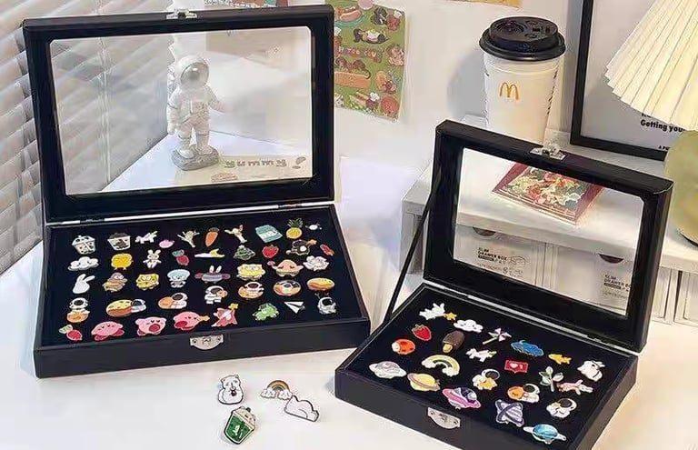 Enamel pins shown at different sizes for scale