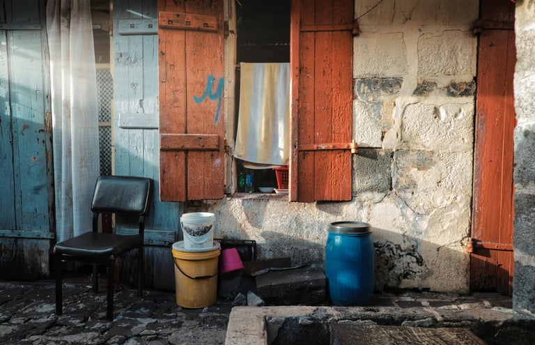 Street photography of a rustic house facade in Mauritius with colorful shutters.
