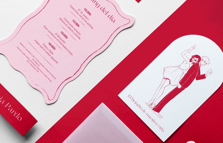 Diferentes elementos que conforman una invitación de boda sobre fondo de color incluyendo invitación ilustrada