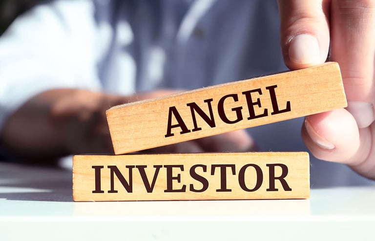person holding wooden blocks that read "angel" "investor"