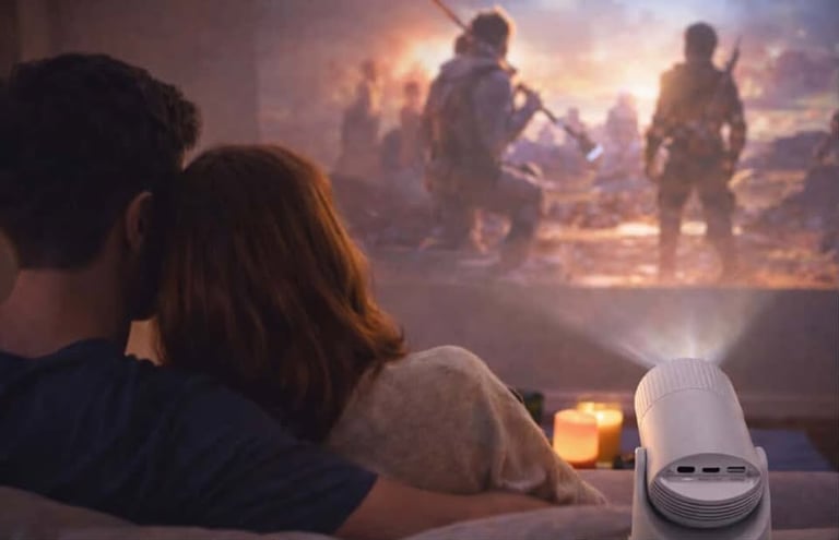 Couple watching a movie projected on the wall using a compact home projector