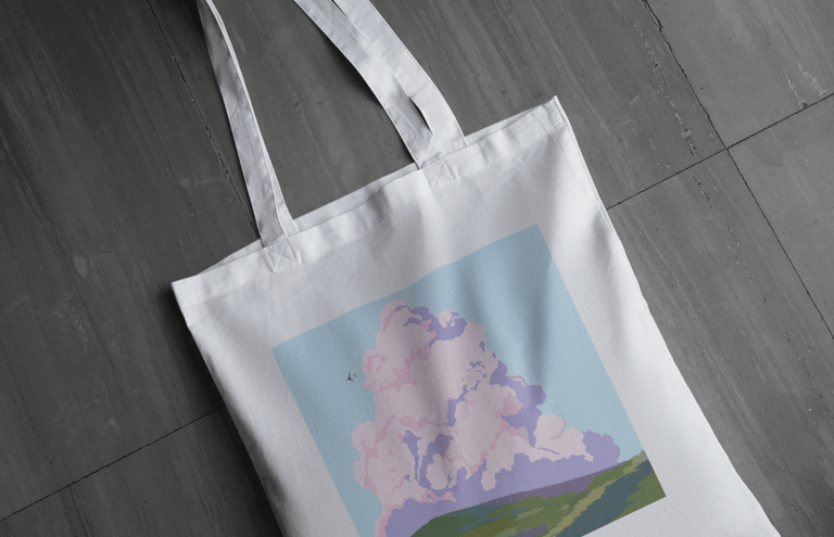 sac en toile tote bag blanc avec une image un gros nuage coloré au dessus d'un pré