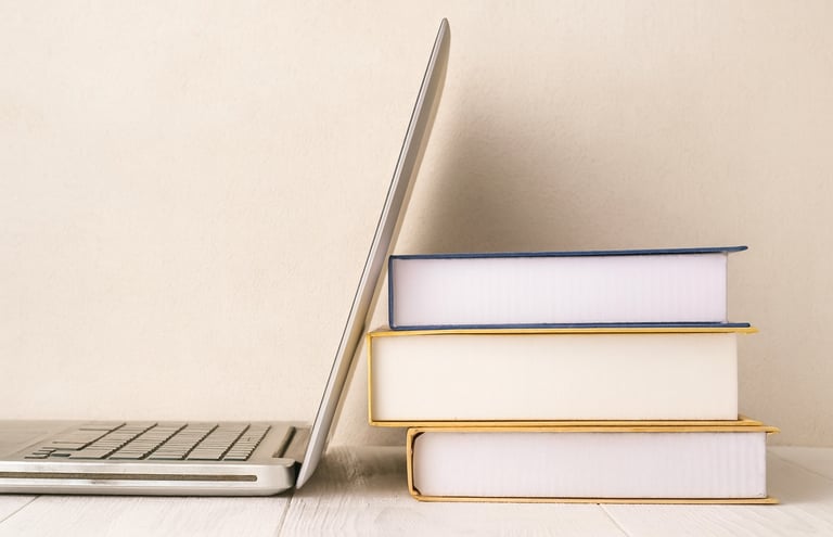 A laptop leaning against some books