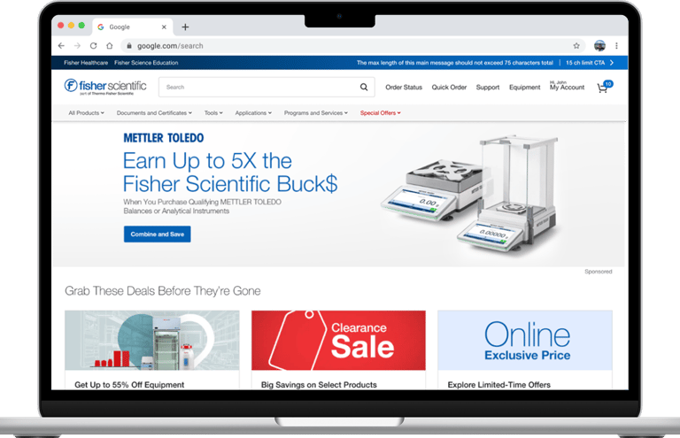 Fisher Scientific website on a laptop screen featuring Mettler Toledo laboratory balances and clearance sale deals.