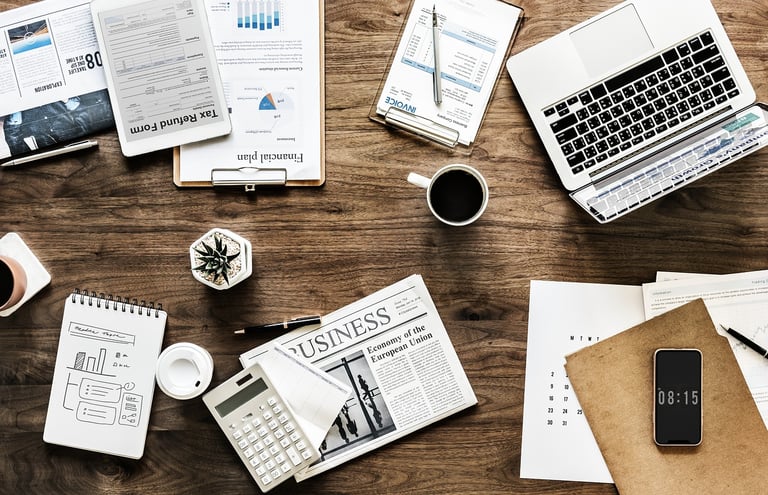 a desk with a laptop and diverse business documents