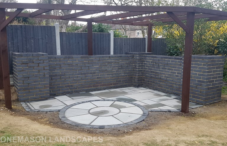 Blue Perforated Brick Wall Planter With Grey Sandstone Circle & Patio Paving & Wooden Pergola