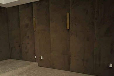 Brown suede wall panels with brass sconces by Solo Home Decor, designed for a modern theater room