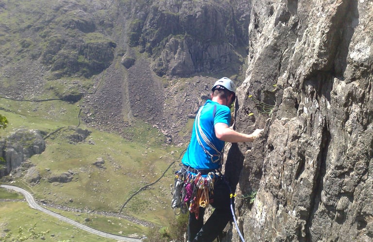 climber high on a rockface, traversing