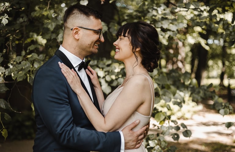 a man and woman standing in front of a tree